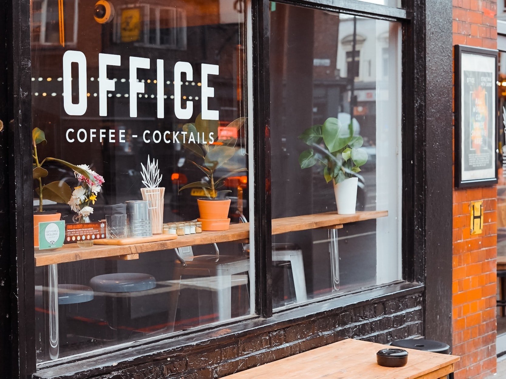 A coffee shop's front window with the name "Office" in vinyl lettering.