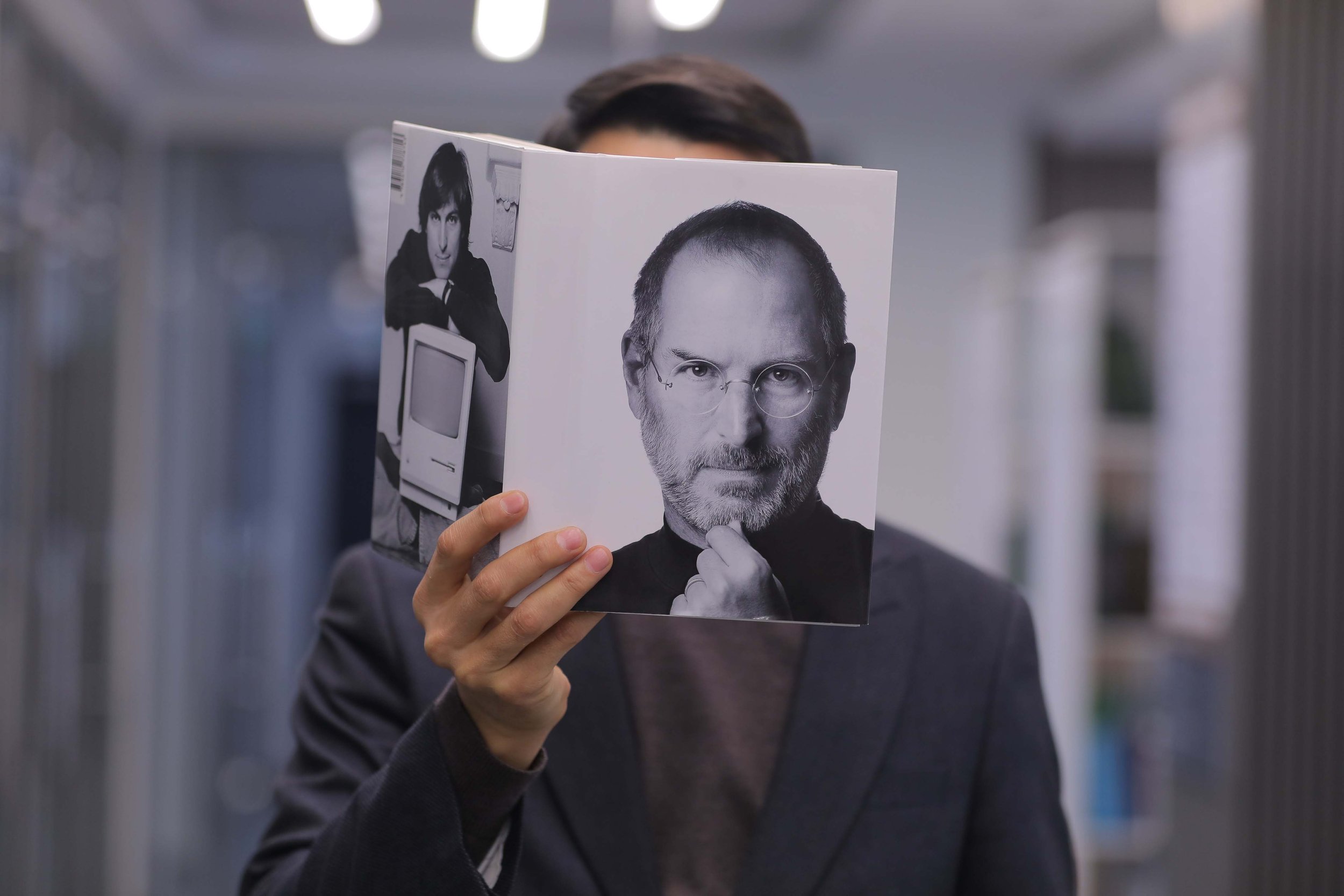 A man holding a copy of Walter Isaacson's Steve Jobs: The Exclusive Biography