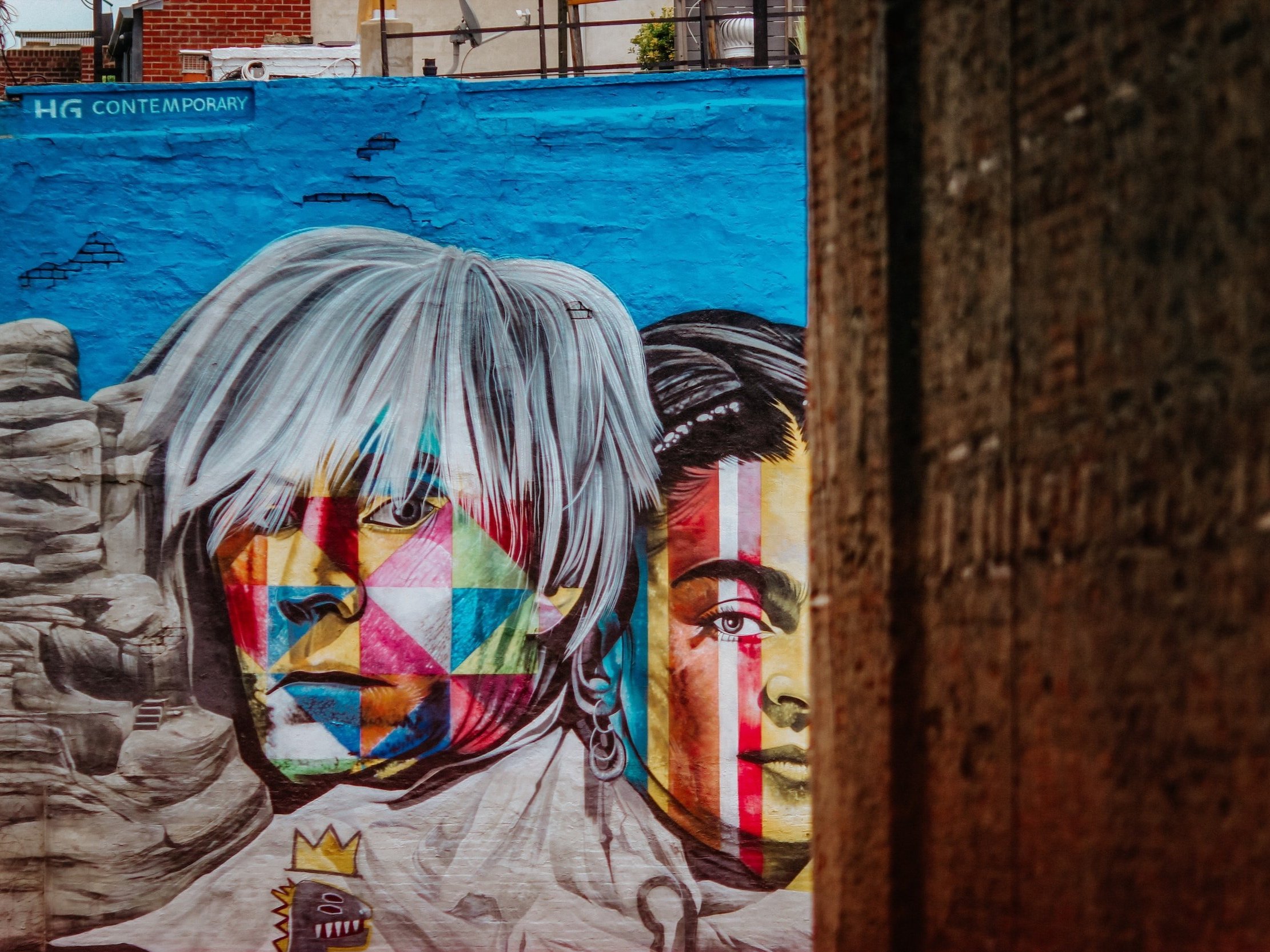 Andy Warhol mural on a wall with his face in abstract colors.