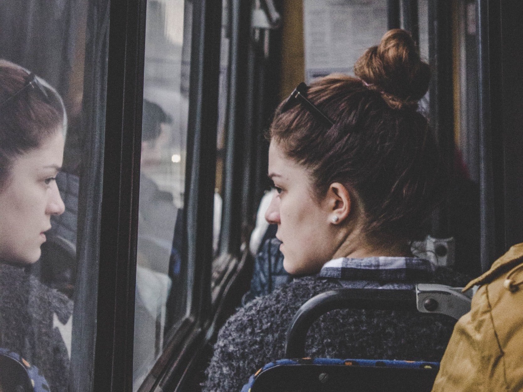 A woman on the bus was deep in thought, staring out the window.
