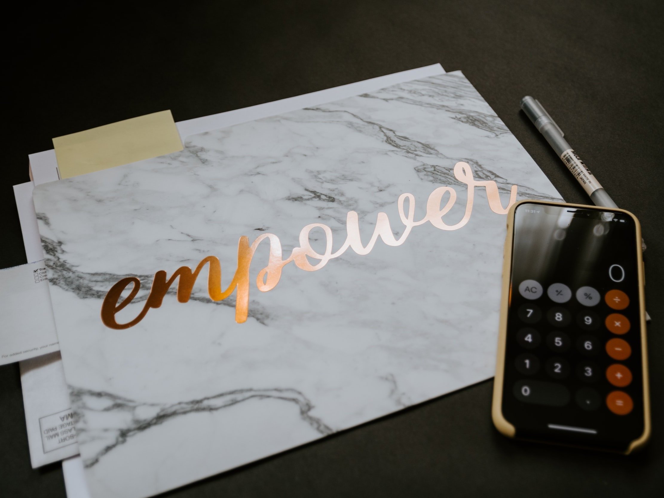 In a marble effect material, the word "empower" is debossed.