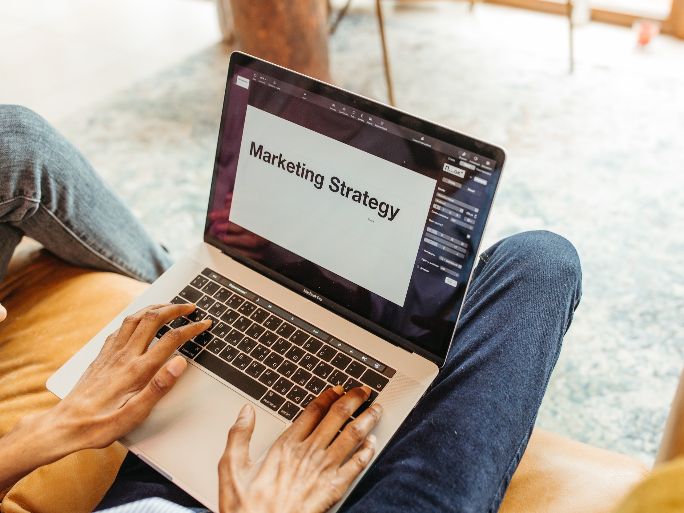 The document titled "Marketing Strategy" was displayed on the screen of an Apple MacBook Pro on a person's lap as they opened it.