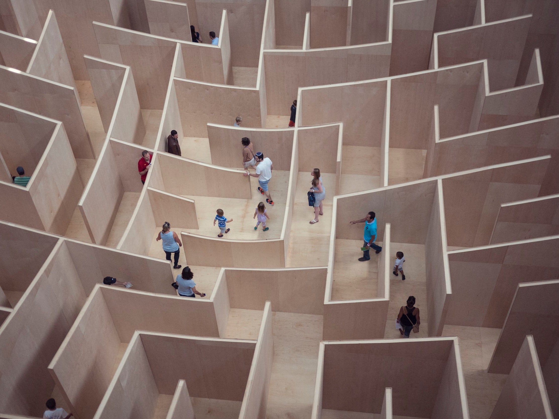 People of varying ages get lost in a wooden maze.