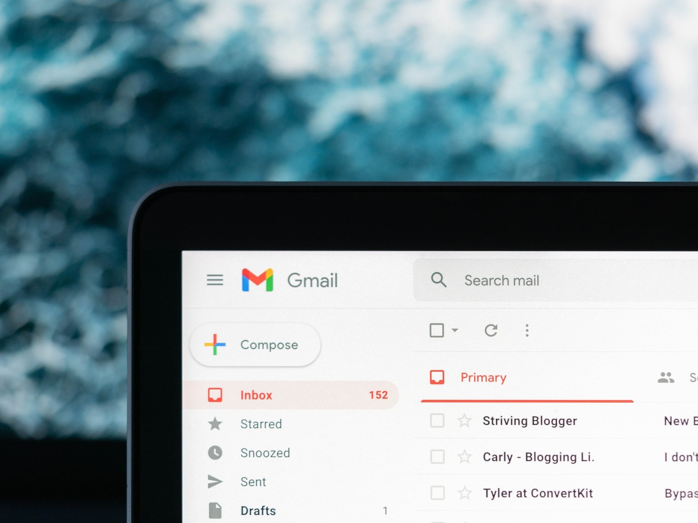 A laptop with a Google Gmail inbox containing emails from various bloggers