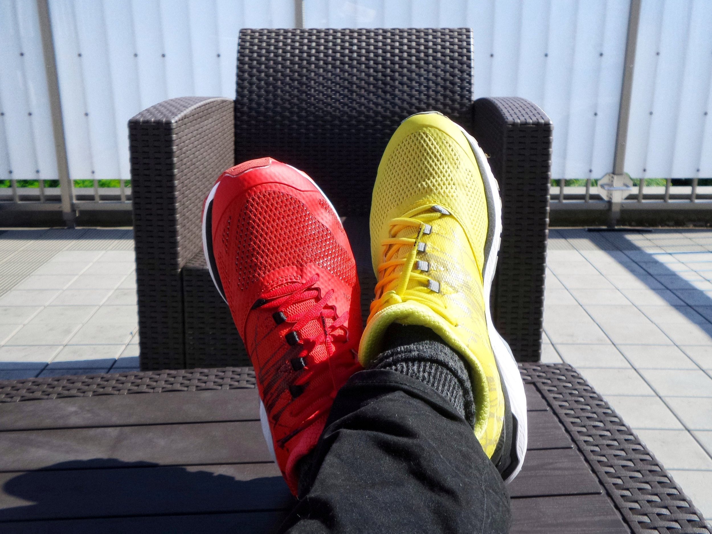 Person wearing mismatched sneakers, one red and one yellow