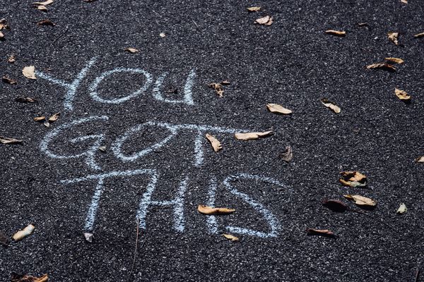 Chalk message 'YOU GOT THIS' on asphalt with scattered leaves, symbolising ways designers can boost their confidence.