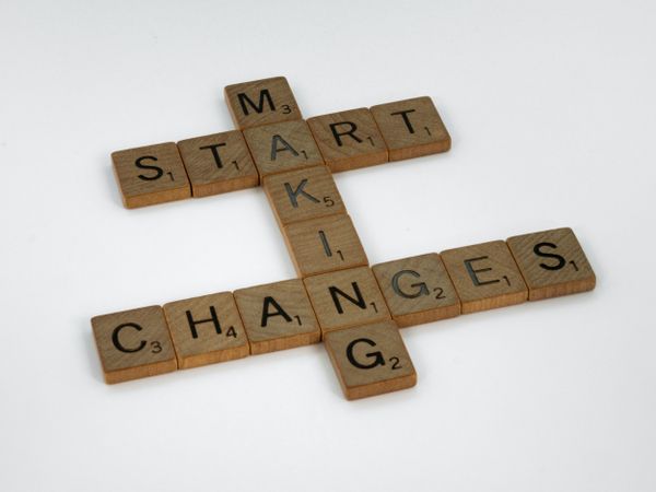 Scrabble tiles arranged to spell "MAKING CHANGES START" on a white background, symbolising personal growth.