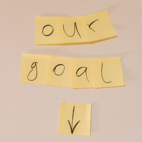 Sticky notes with handwritten letters spell out "goal", signifying goal-setting and having a clear purpose or objective.
