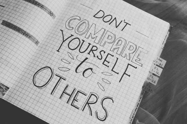 Handwritten text "Don't compare yourself to others" on lined paper, advising against comparing oneself negatively to others.