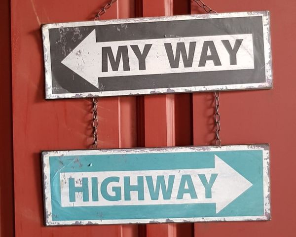 Road signs "My Way" & "Highway" show divergent paths, illustrating how taking a different approach can lead to novel results.