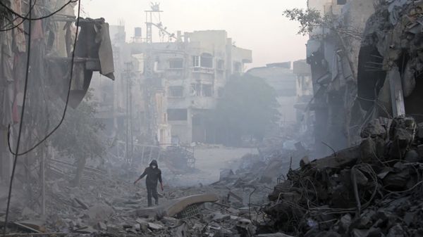 Bir adam, Gazze Şeridi'nin orta kesimindeki Bureyc Mülteci Kampı'nda, İsrail hava saldırılarında yıkılan binaların enkazı ara