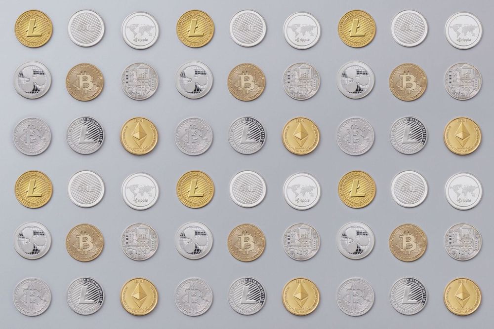 Cryptocurrency coins beside a laptop showing market data, illustrating regulated crypto-asset services
