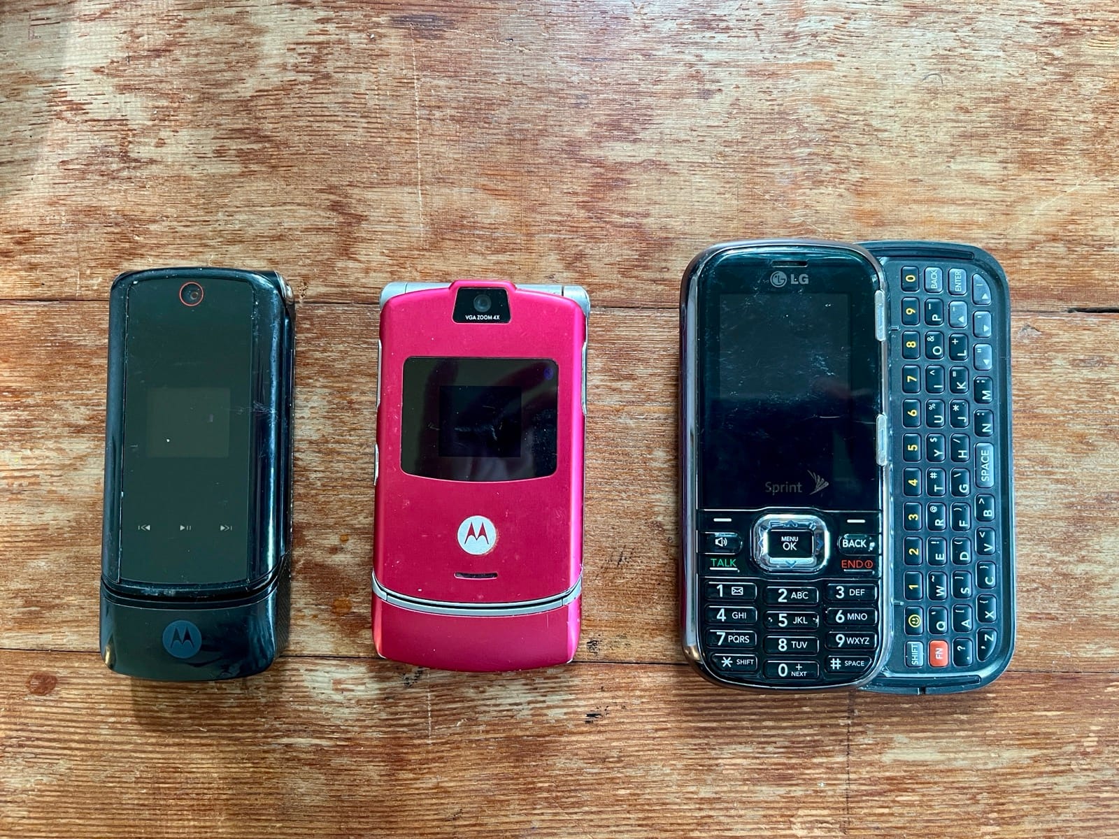 Three old cell phones lined up beside each other. 