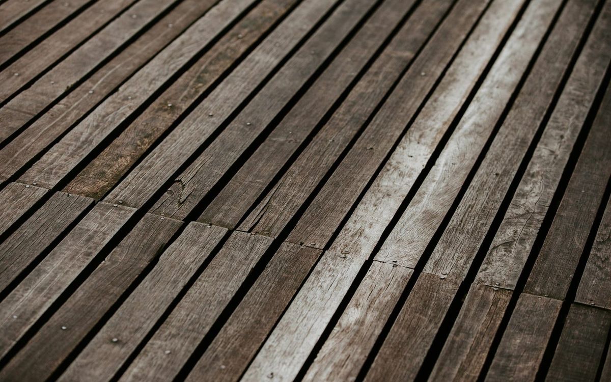 Weathered wooden deck boards with visible grain and changes in color.