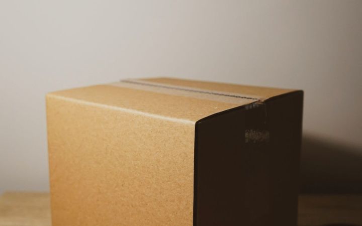 A plain taped cardboard parcel on a wooden table