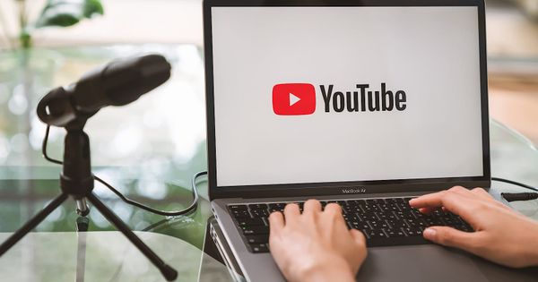 YouTube podcast creator desk with microphone, video screen, audience dashboard, and distribution scorecard
