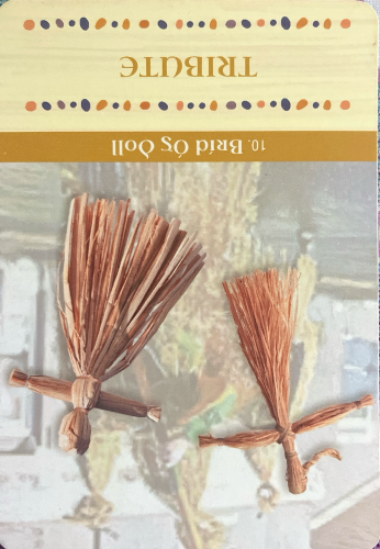 A card from the Brigid oracle deck by Moon Mná is shown. It's card #10 Bríd óg Doll. It's yellow and says "Tribute" with a picture of two dolls woven from straw. 