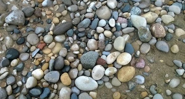 A single stone on a sandy lakeshore, symbolizing stability and minimalist design in AI systems and tactical soccer.