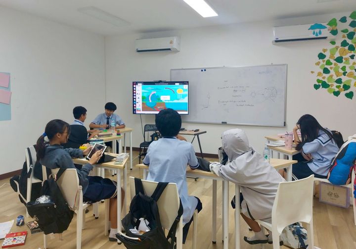 Students in a classroom watching a presentation on a screen, illustrating AI use in education