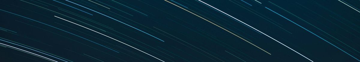 Streaks of light in a night sky, showing the motion of stars in a long-exposure photograph.