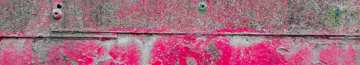 Flaky, corroded red paint on metal.