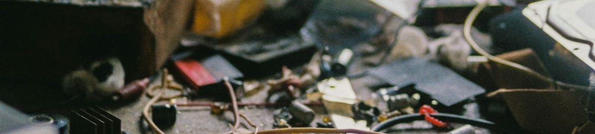 Electronic parts in a disorganised mess on a workbench.