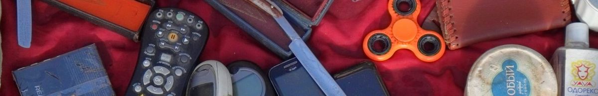 A hodgepodge of junk: a remote control; old mobile phones; a fidget spinner; bottles and tubs of unknown substances