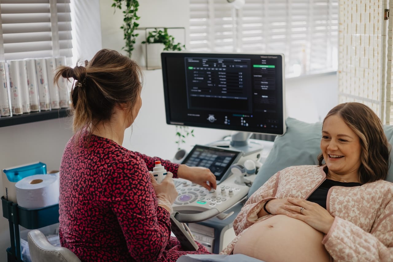 A parent looking relaxed during a pregnancy scan at Sneak-A-Peek Ultrasound.