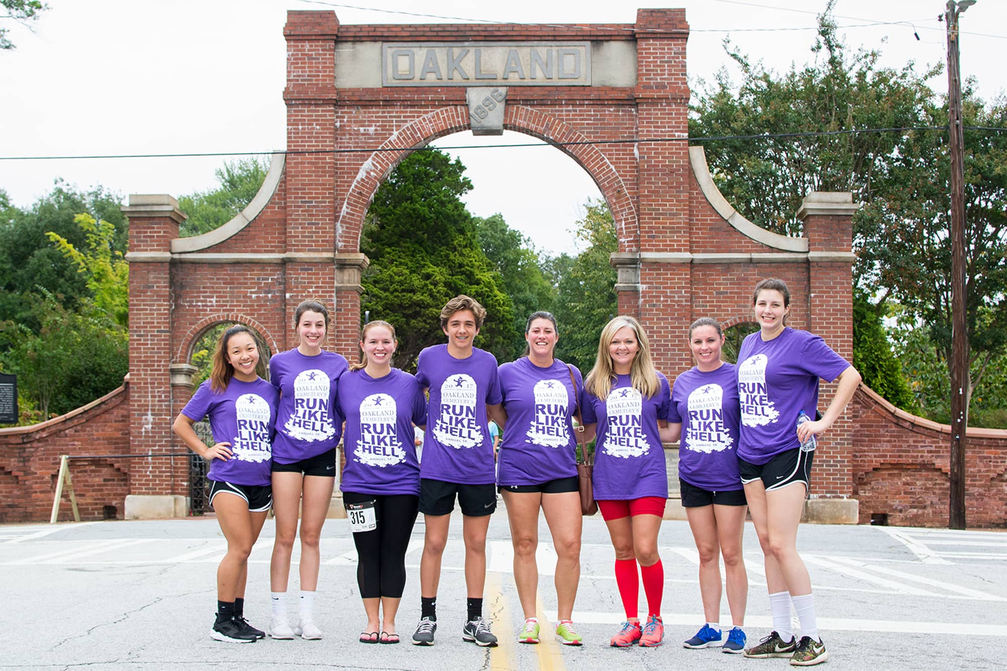A group of runners that are all wearing the same shirts promoting the event.