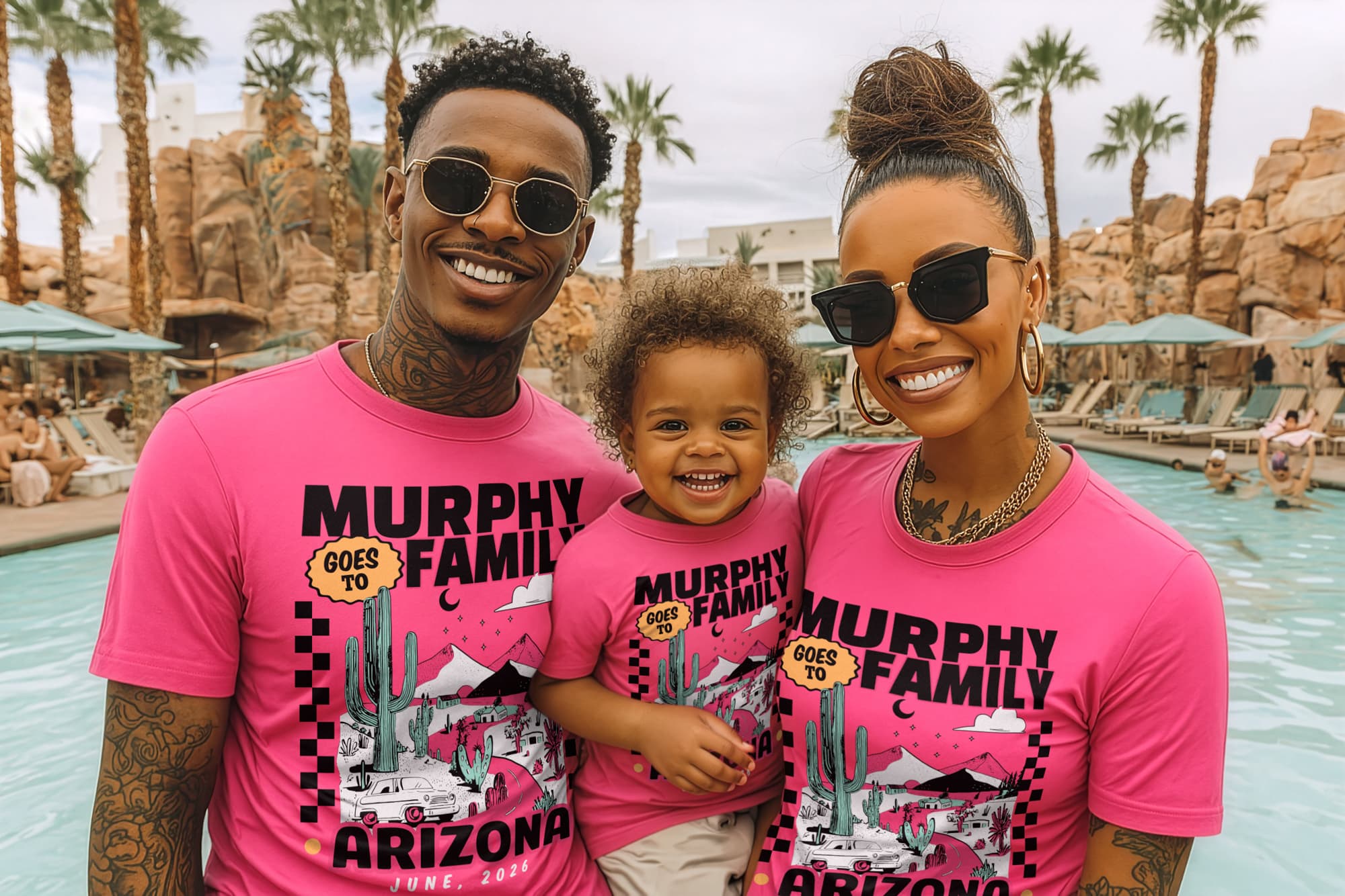 A joyful family of three wearing matching pink "Murphy Family Goes to Arizona" shirts poses by a pool. Palm trees and rocks enhance the vacation vibe.