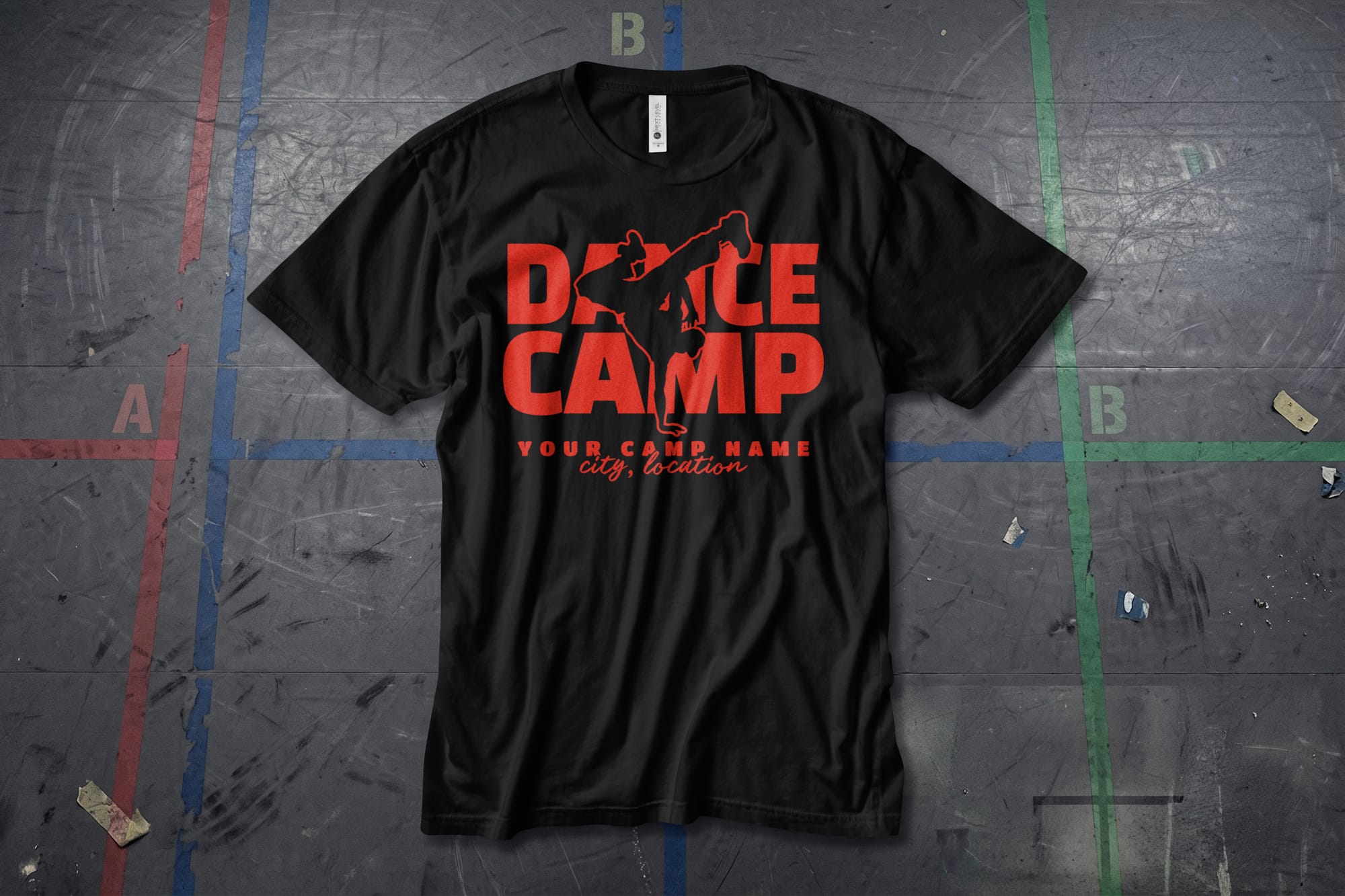 Black T-shirt with bold red text "DANCE CAMP" featuring a dancer silhouette. Below, placeholder text reads "Your Camp Name, City, Location," placed on a textured floor.