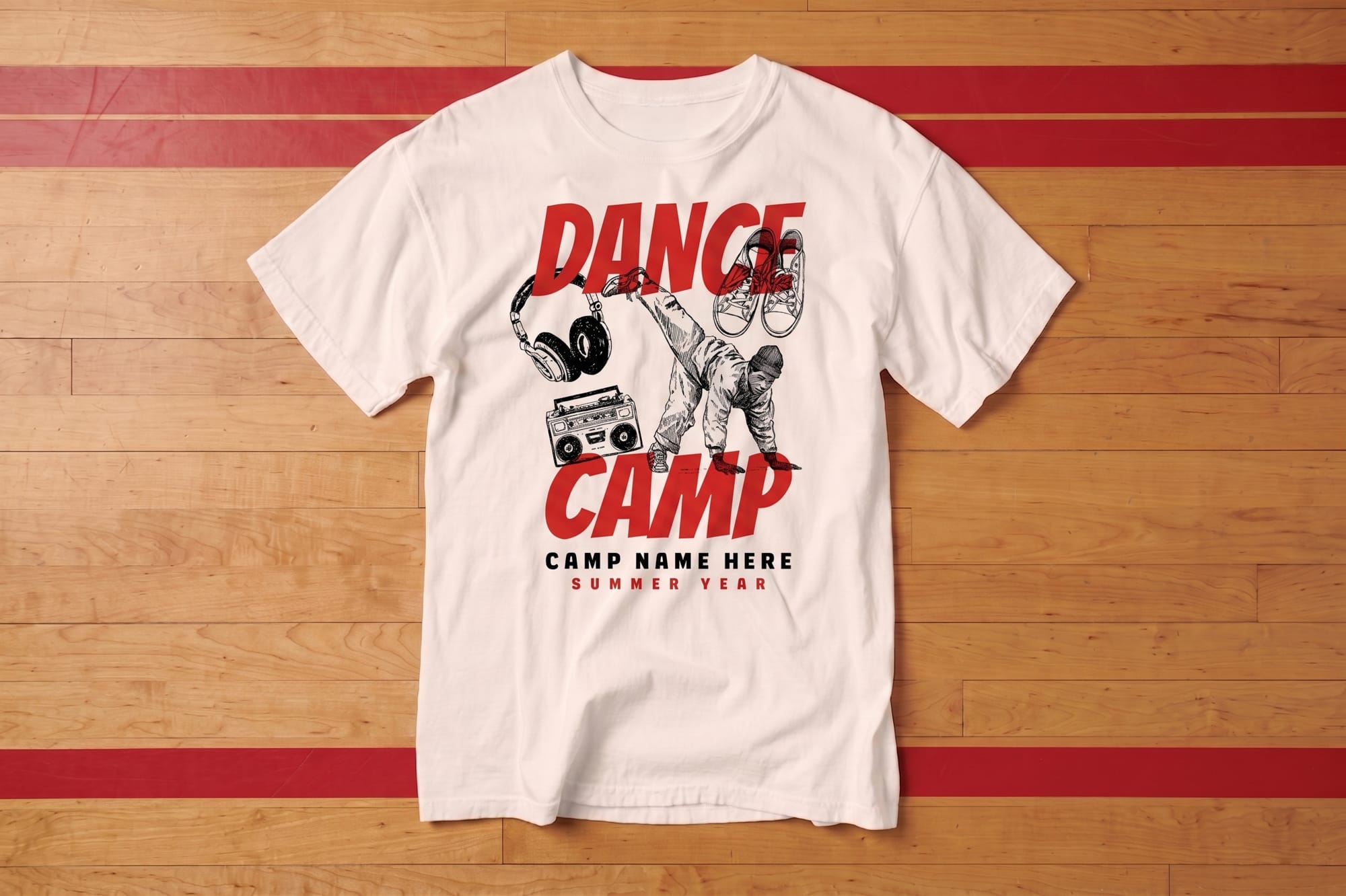 White T-shirt on a wooden floor with "Dance Camp" in bold red letters. Features drawings of a dancer, boombox, headphones, and hanging sneakers.