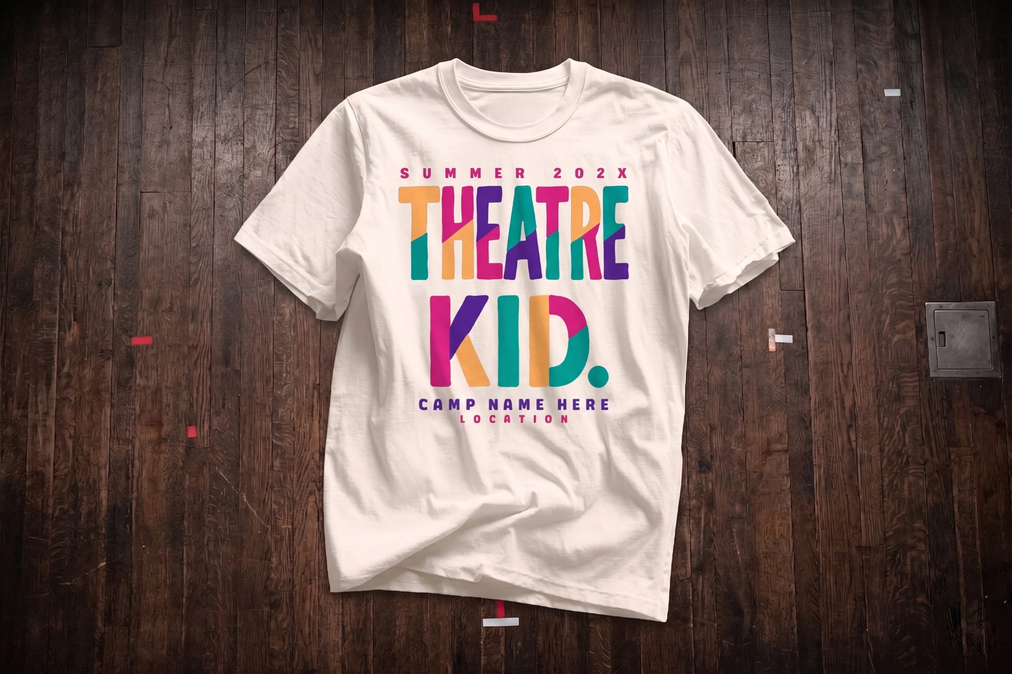 Natural white crewneck t-shirt with a multicolor custom-printed 'Theatre Kid' summer camp design on a wood stage floor