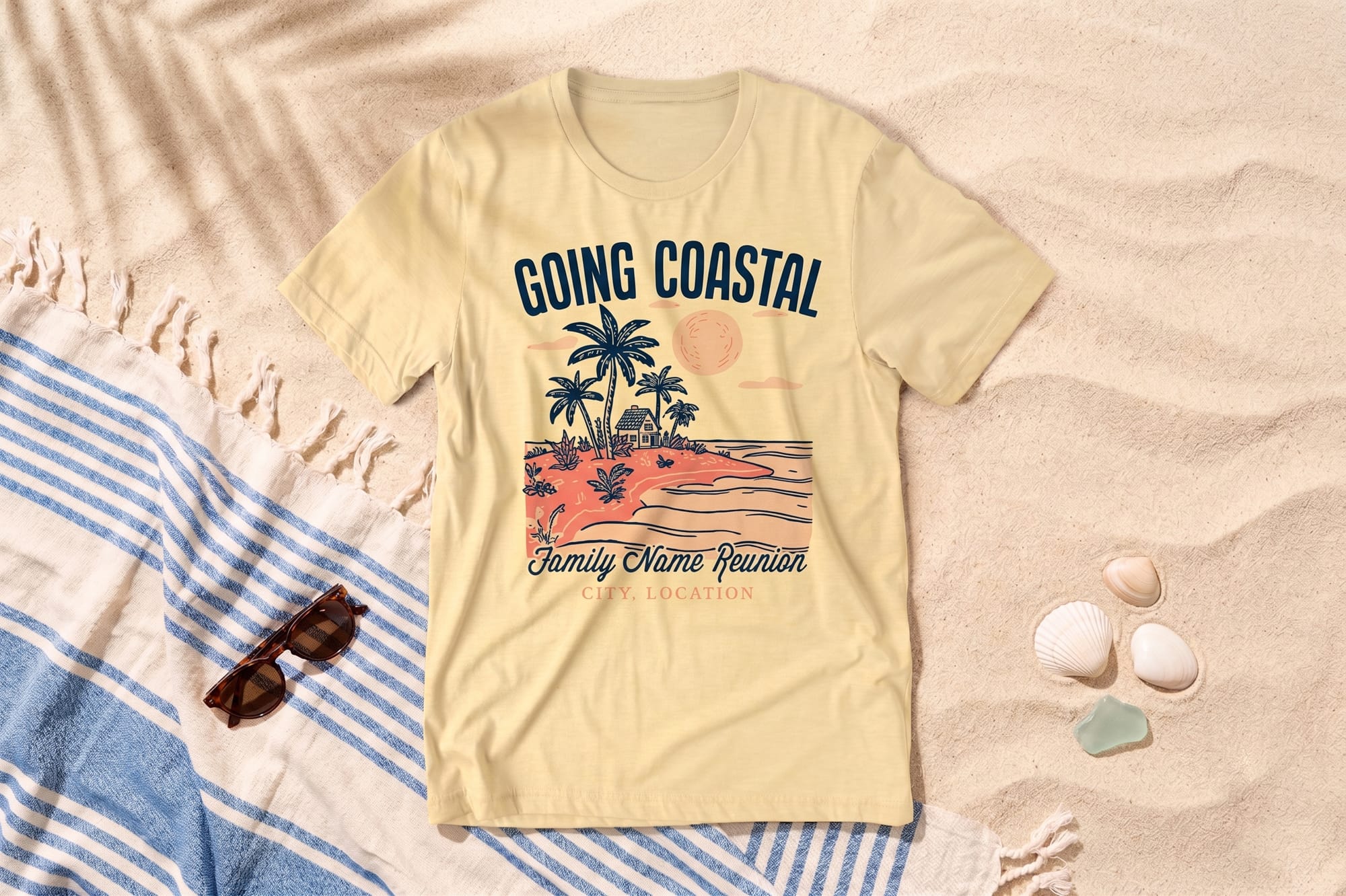 Light yellow crewneck tee with a retro coastal scene print reading 'Going Coastal' and customizable family reunion text, flatlay on sand