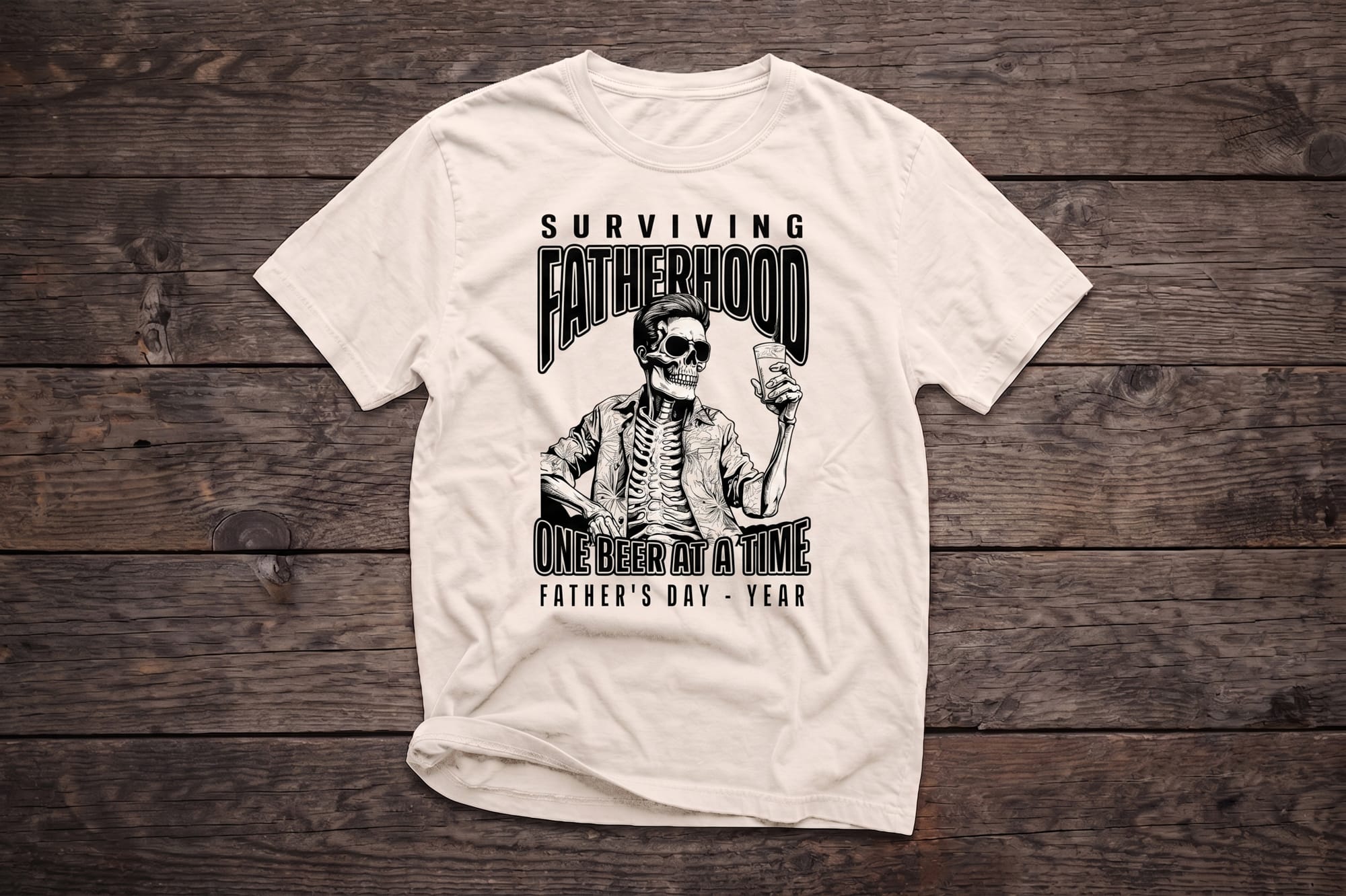 White crewneck tee with black screen-printed skeleton dad holding a beer and text 'Surviving Fatherhood One Beer at a Time'