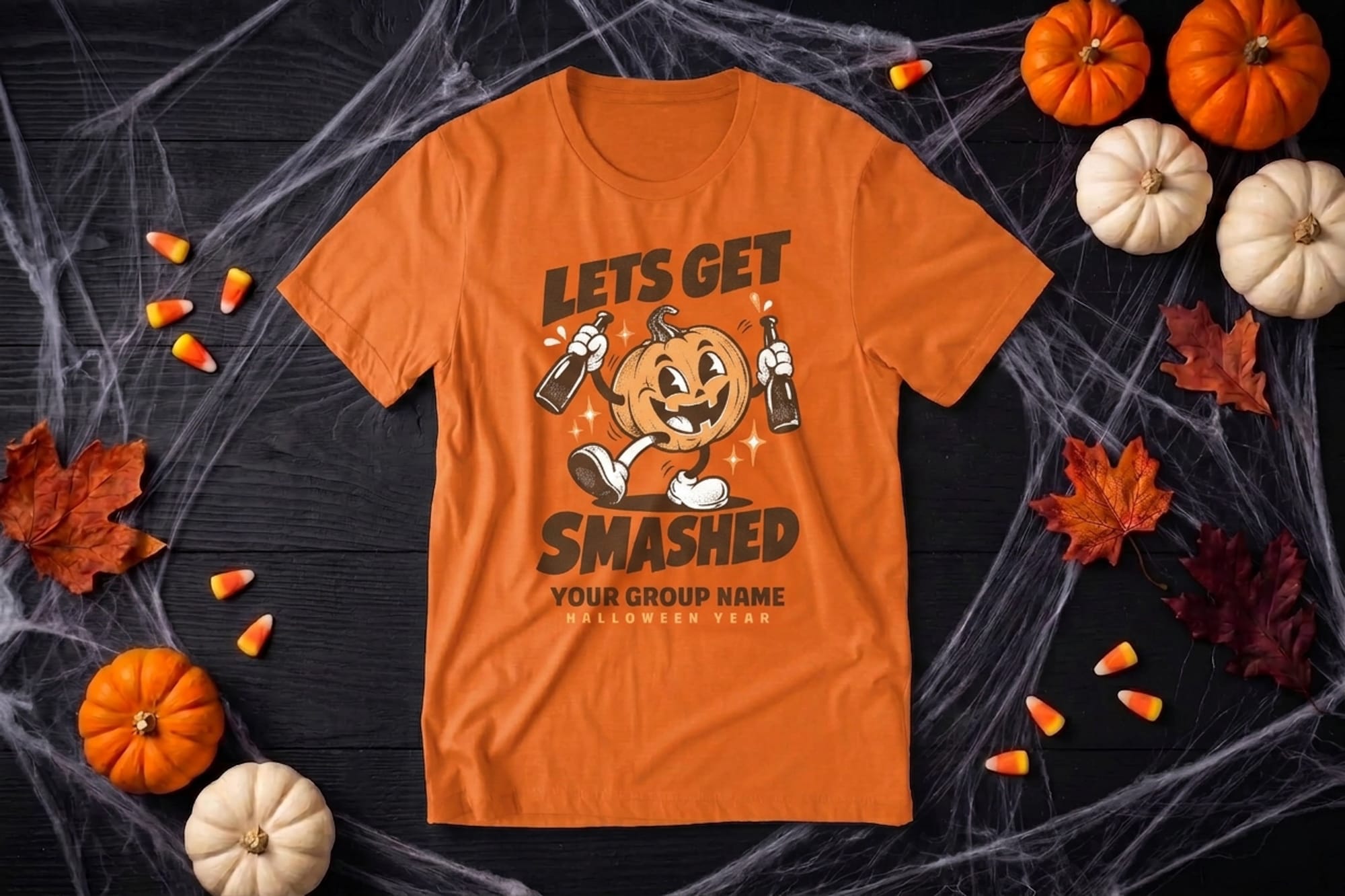 mockup of a halloween flatlay shirt. design is of a pumpkin and it says lets get smashed