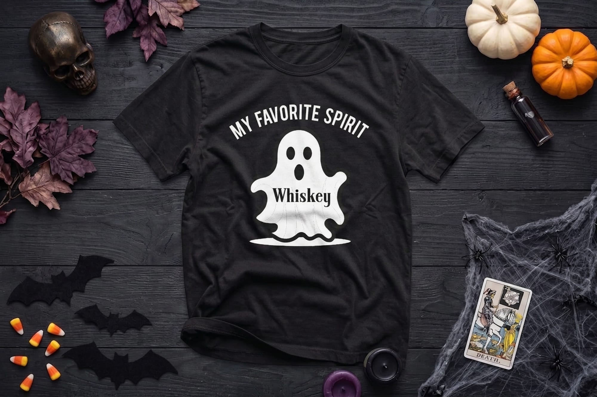 mockup of a halloween flatlay shirt. design is of a ghost and it says my favorite spirit - whiskey