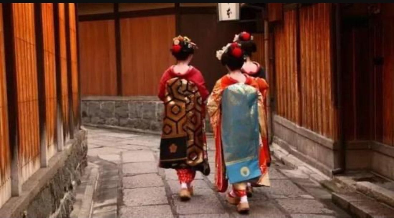 京都巷子里并行的两位和服着装者