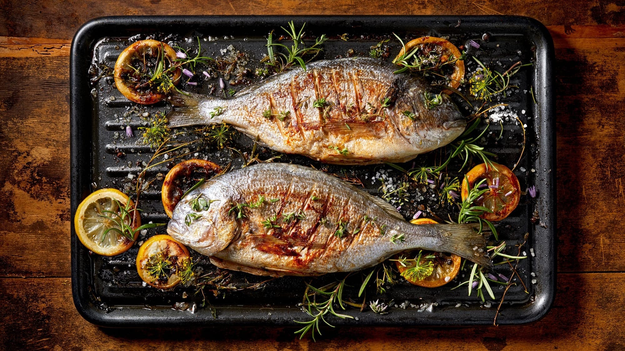 Two sea bream on a griddle.