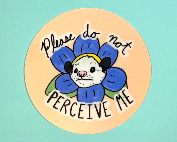 Sticker with a drawing of a possum in the middle of a flower, with the words "Please do not perceive me"