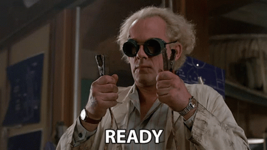 Doc Brown holding two electrical clamps saying, "ready."