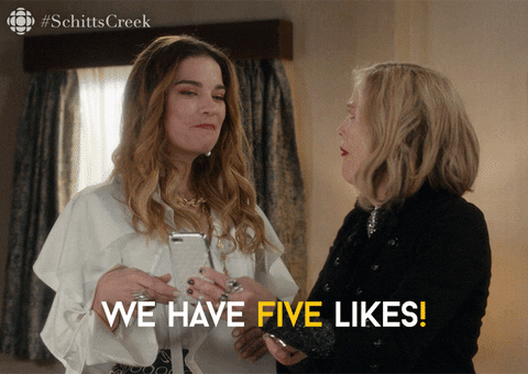 Alexis and Moira Rose looking at her phone saying, "We have five likes!"