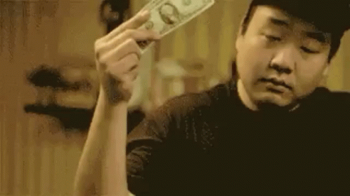 a man holds a single dollar bill, puts it on his palm, and "makes it rain"