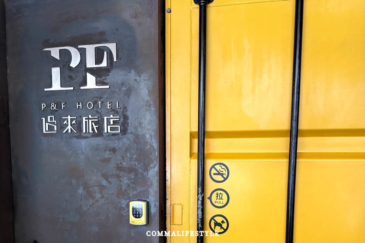 黃色大門加上鐵把手的過來旅店門口