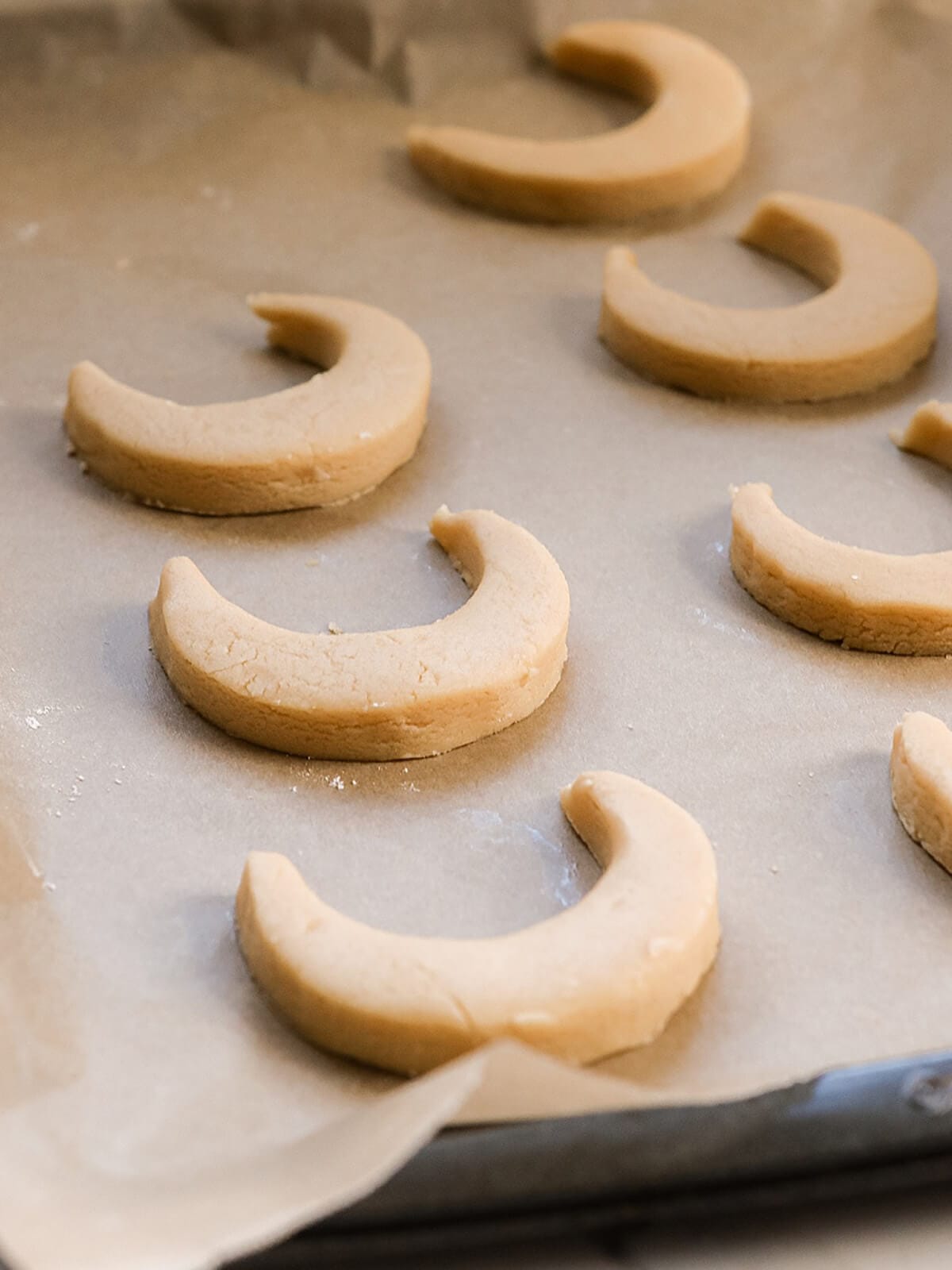crescent ramadan inspired moon sugar cookies on parchment paper.