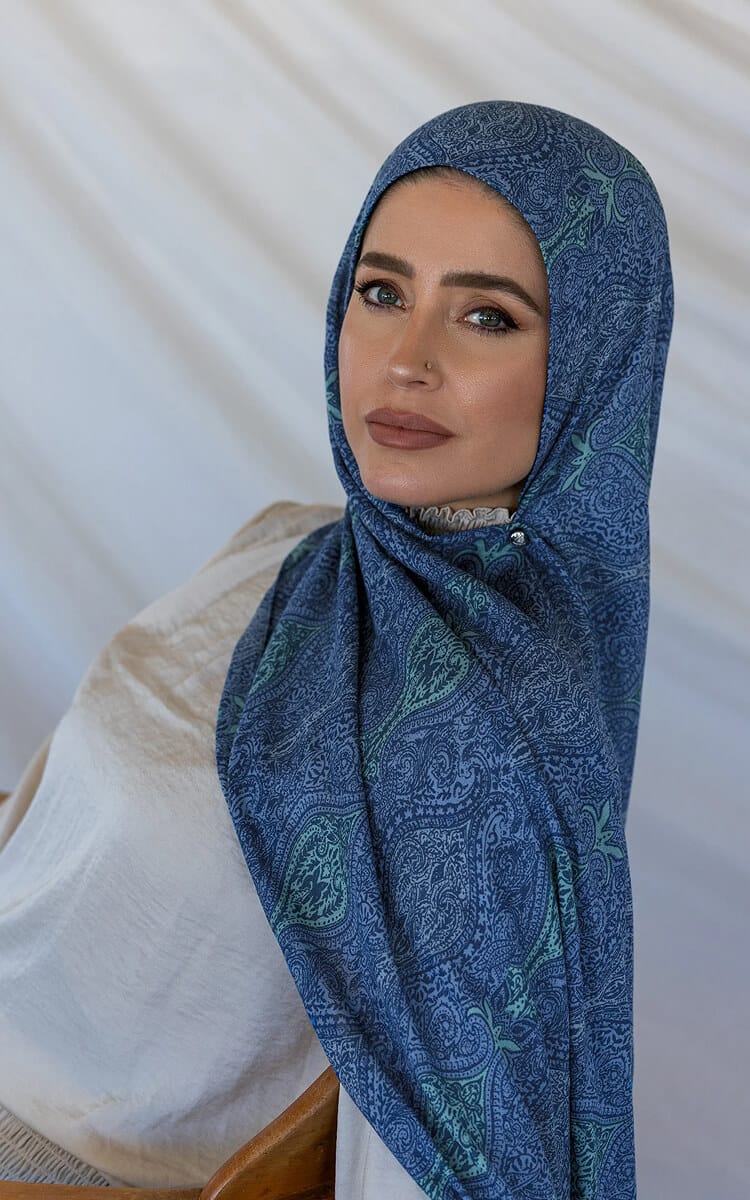 Woman wearing a blue paisley hijab.
