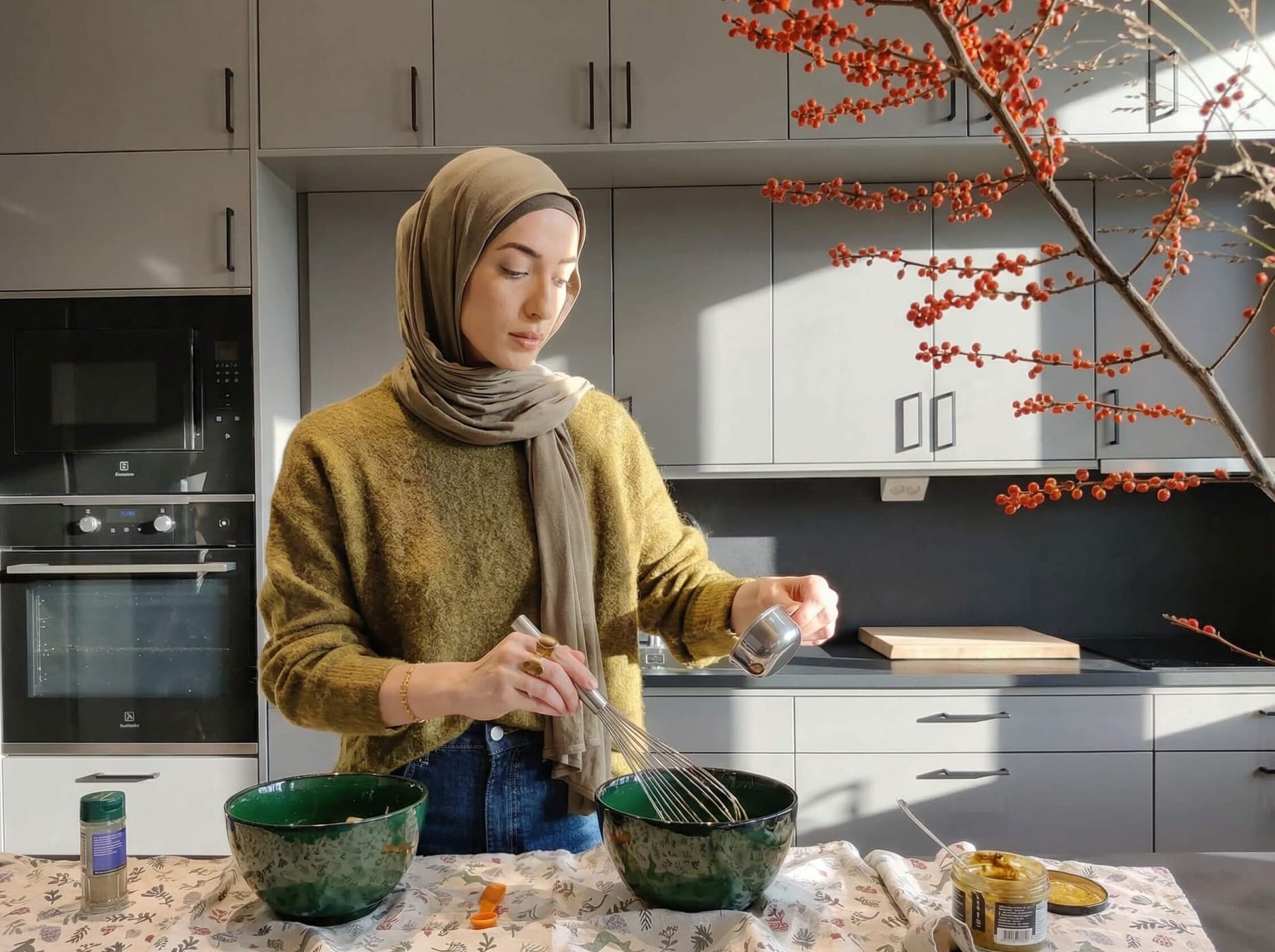 Hijabi blogger stirring pistachio cream into the melted chocolate and butter for Reindeer Chow