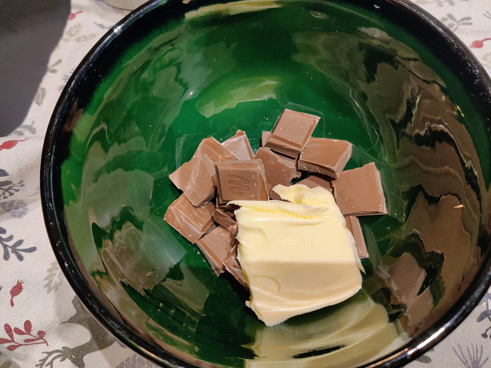 Milk chocolate pieces and butter in a bowl before melting for pistachio Reindeer Chow