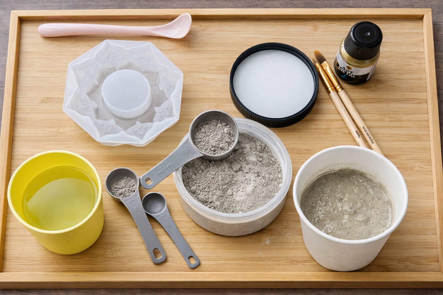 Overhead view of materials and steps for mixing decorative concrete powder for a handmade candleholder DIY