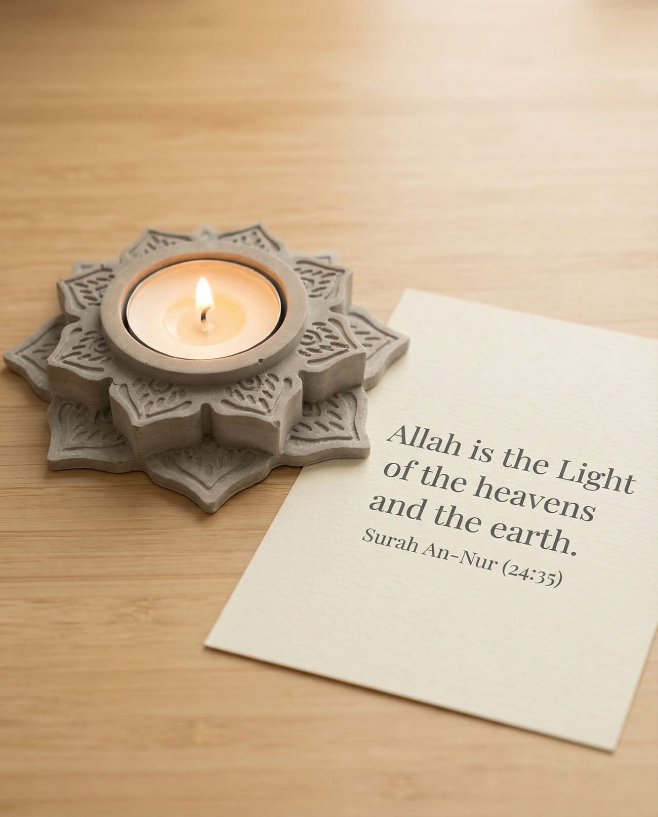 Elegant concrete candleholder with geometric pattern and lit candle beside Surah An-Nur verse for Ramadan decor